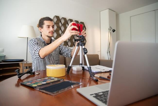 Guy using a phone on a tripod to record a video