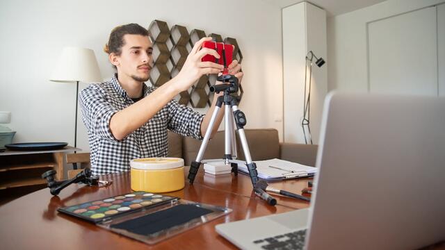 Guy using a phone on a tripod to record a video